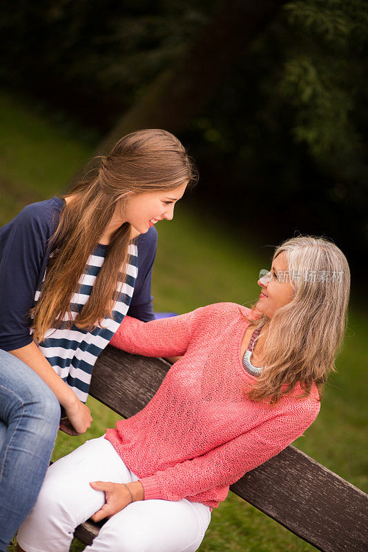 妈妈和女儿在公园长椅上聊天