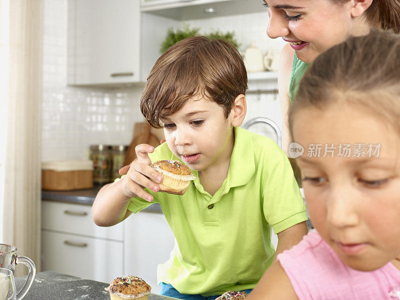 妈妈和孩子们在厨房里准备纸杯蛋糕