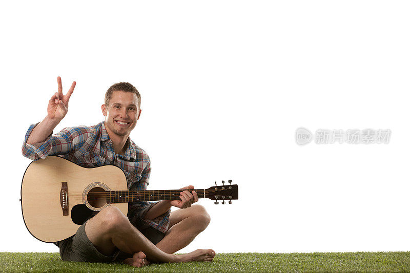 一个弹着吉他，摆着和平手势的人