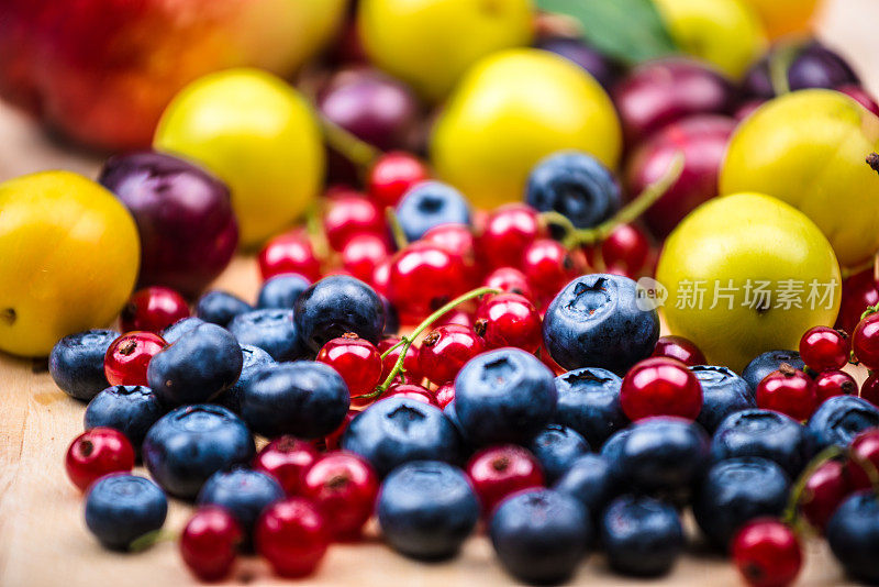 蓝莓，红醋栗，浆果，不同的水果在木制的背景