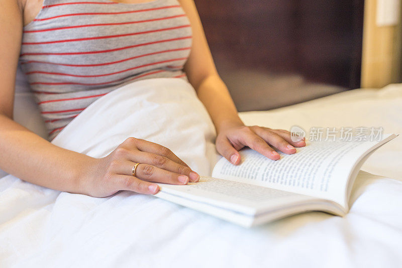 一个女人躺在床上看她最喜欢的书
