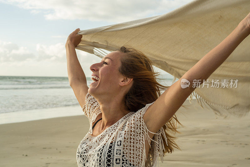 一个白人女人在风中拿着毯子