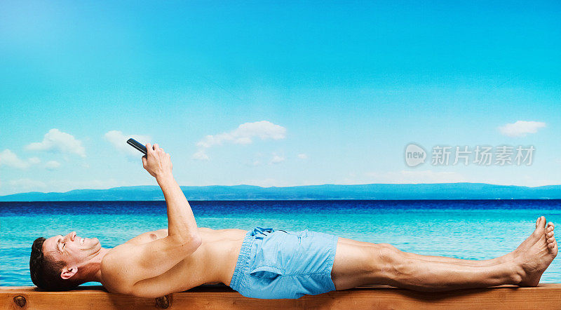 在海滩上用手机的男人