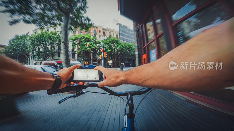 POV在城市里骑自行车，同时在手机上查阅地图