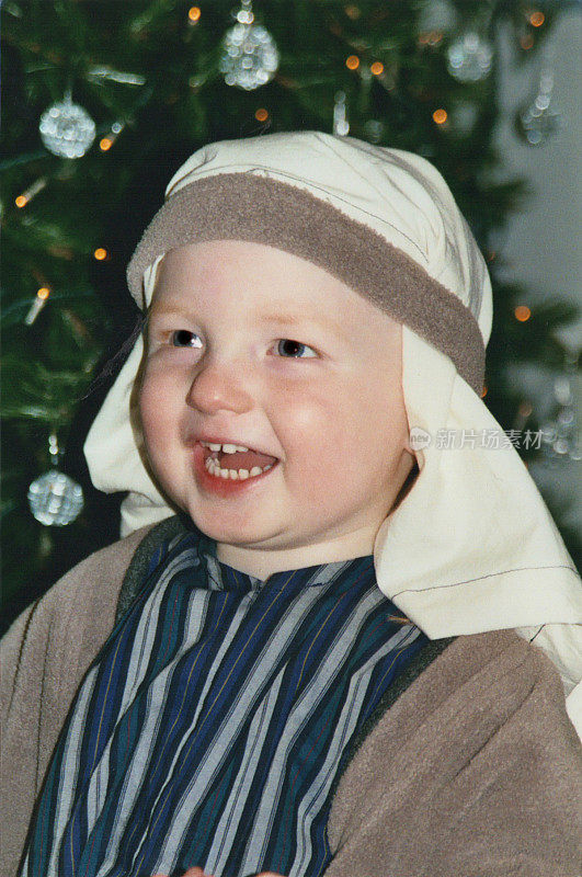 小男孩装扮成牧羊人的形象，扮演圣诞基督诞生