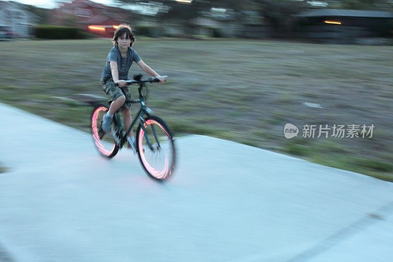 男孩骑自行车。自行车红灯。
