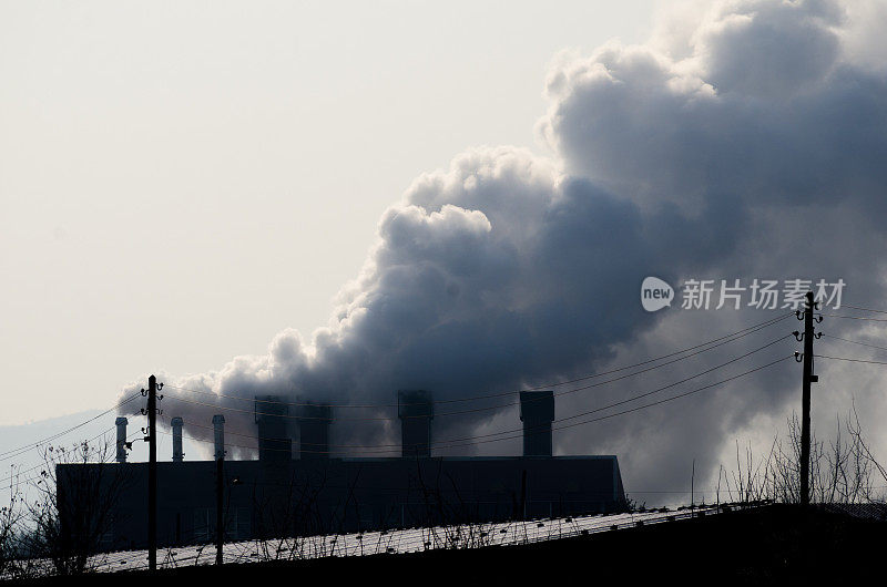 污染。多个煤炭化石燃料发电厂的烟囱排放二氧化碳污染。黑暗的形象。硬的对比。用胶片颗粒