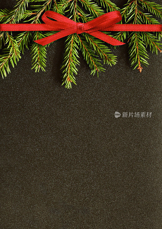 黑色的圣诞背景与冷杉树枝和红色丝带蝴蝶结