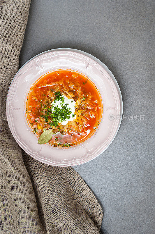 灰色的石头桌子上，老式盘子里装着俄罗斯卷心菜汤。