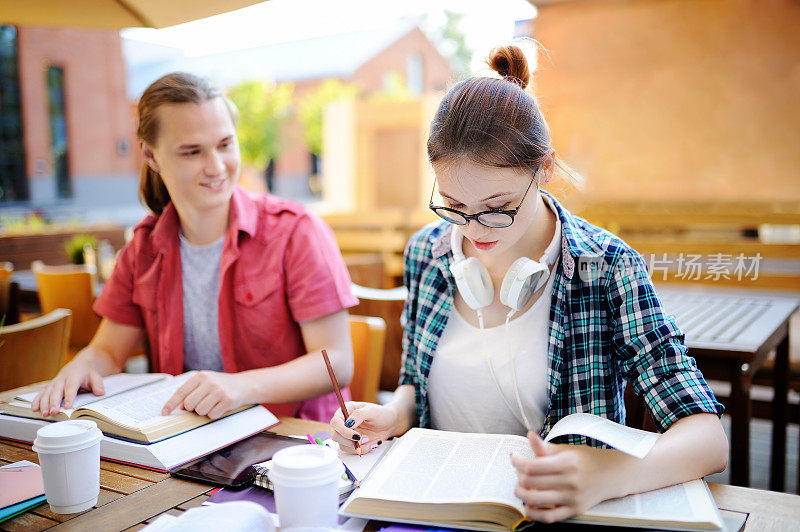 年轻快乐的学生与书和笔记在大学校园