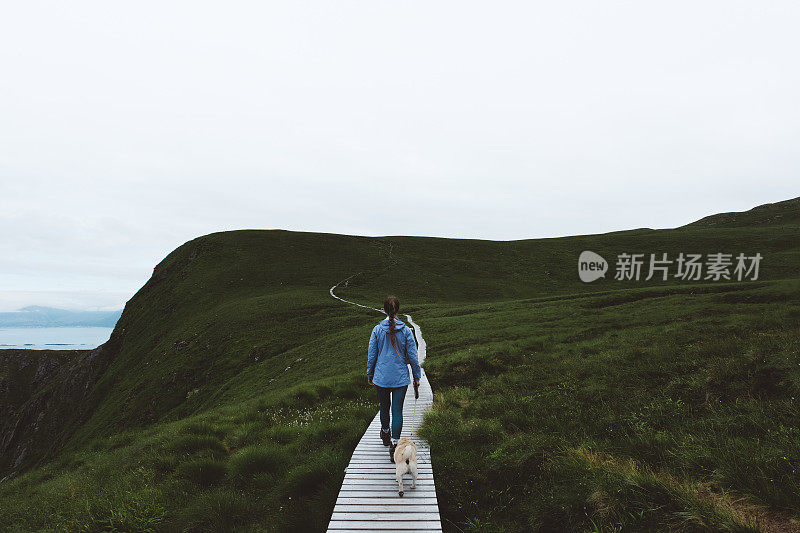 妇女和狗在挪威北部岛屿徒步旅行