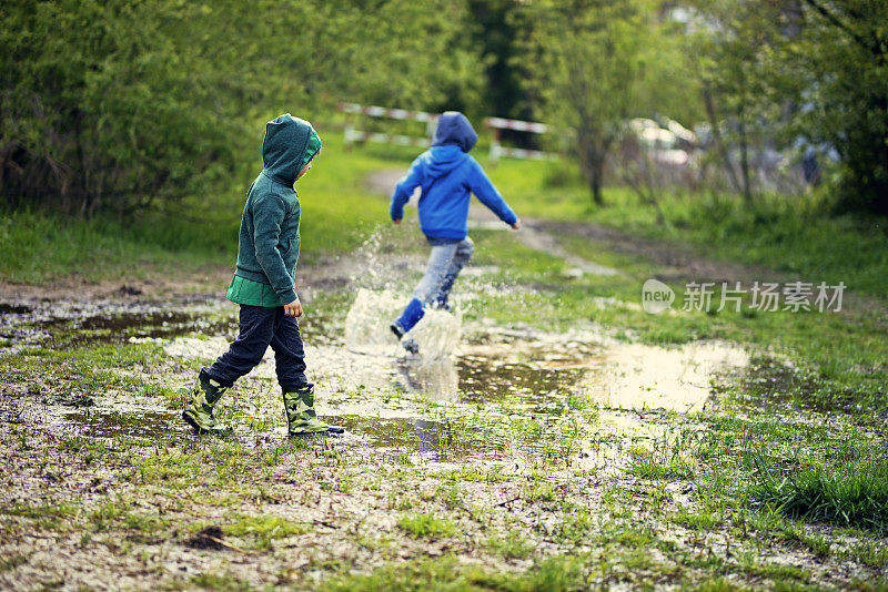 小男孩在泥泞的水坑里奔跑