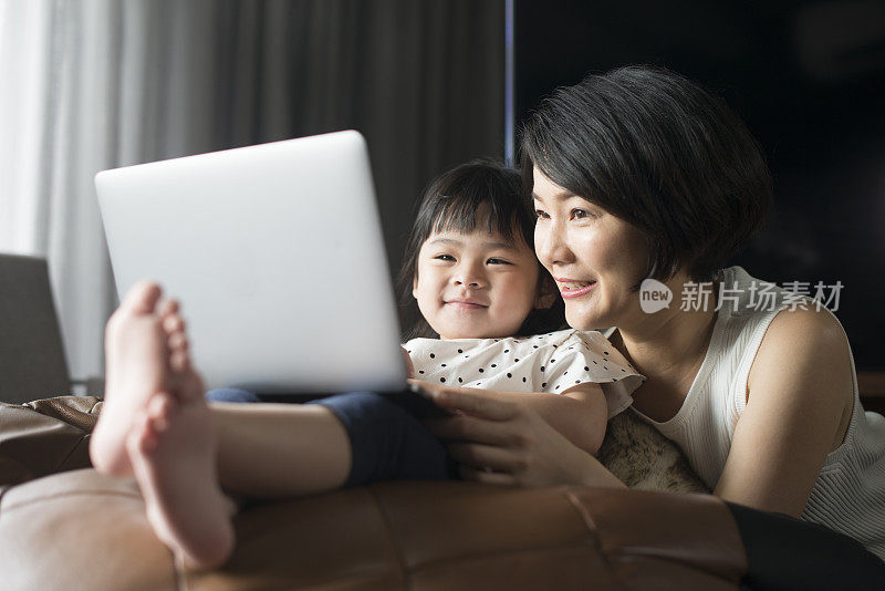 亚洲母亲和女儿看笔记本电脑