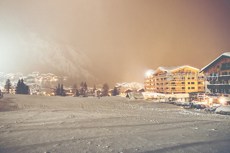 冬天，在欧洲阿尔卑斯山脉的雪夜，法国滑雪胜地瓦尔德泽尔照亮了村庄