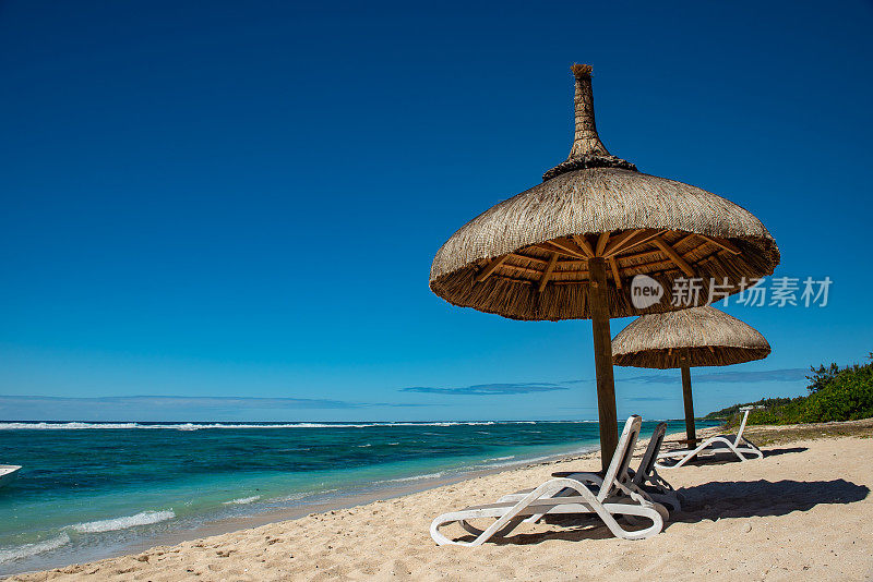 毛里求斯拉斐特邮政海滩，有日光浴躺椅和遮阳板。