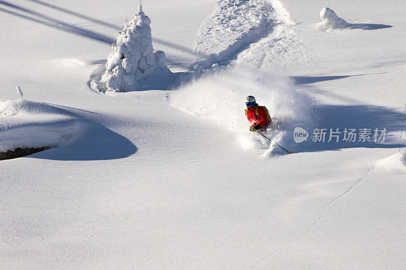 在一个美丽的冬日里，自由滑雪者在厚厚的粉雪中滑行