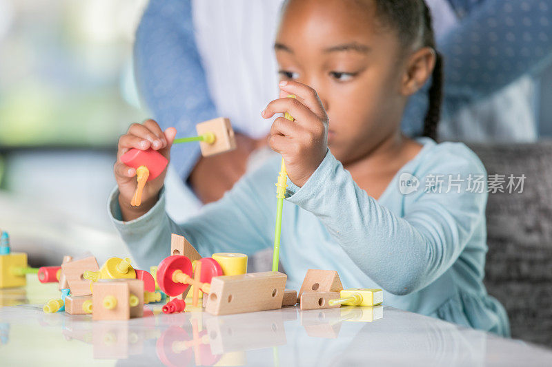 年轻的青少年在桌子上一起处理STEM模块