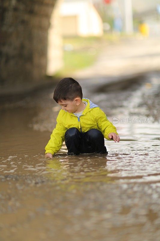 孩子们在雨坑里玩耍