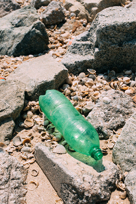 海滩上的垃圾和塑料瓶-海洋环境污染的概念