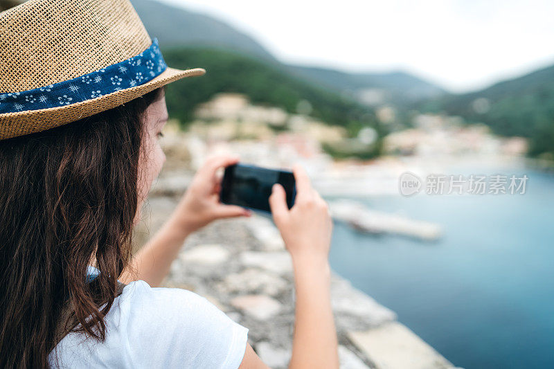 在海边拍摄照片的女人