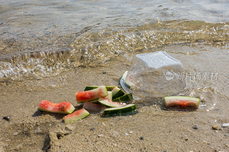 海滩污染。塑料碗和海滩上的其他垃圾