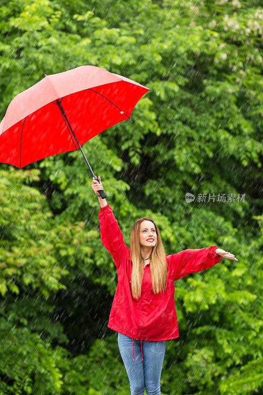 带着红伞的女人在雨天玩