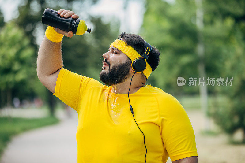 一个超重的男人往他脸上泼水