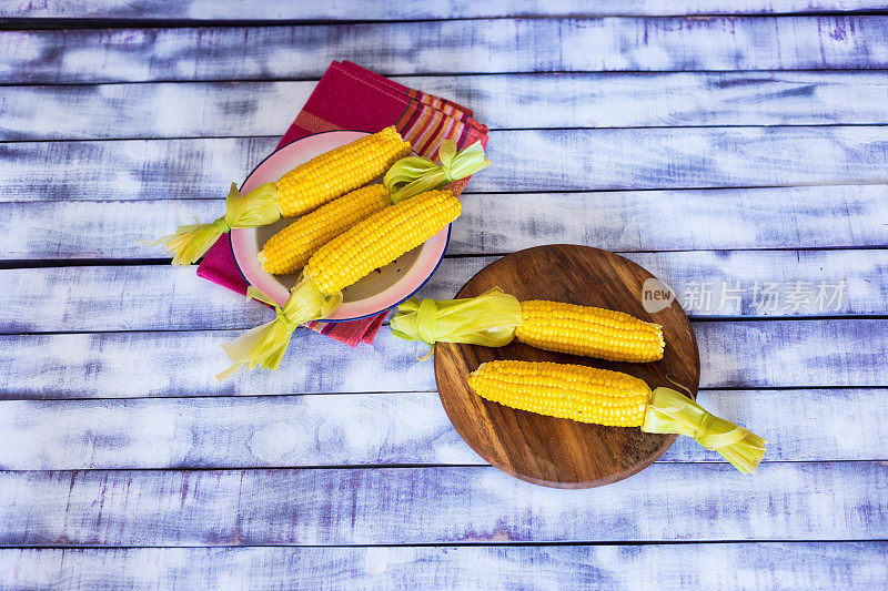 新鲜煮熟的玉米放在盘子里，特写