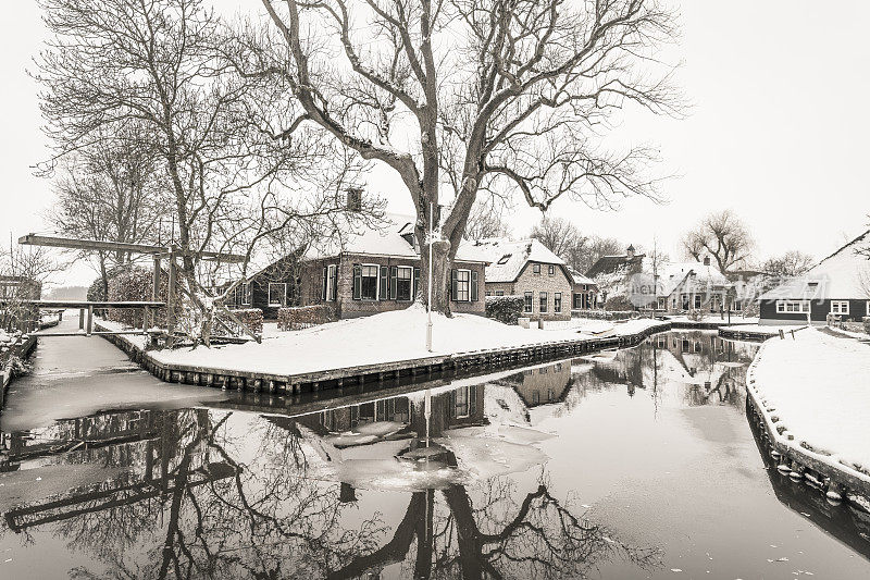 在一个寒冷但美丽而平静的冬天，Giethoorn村附近的Dwarsgracht有积雪的运河