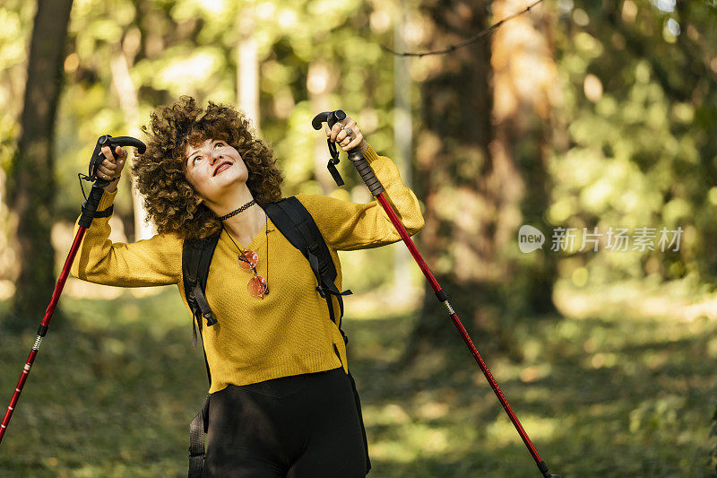 拿着登山手杖的年轻女子在山顶