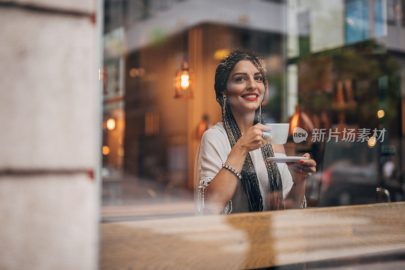 一位女士坐在市中心咖啡馆的咖啡休息时间