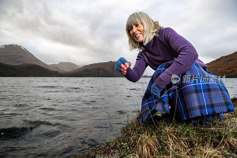 在苏格兰高地的阿尔凯格湖，一名女子在刨平的石头