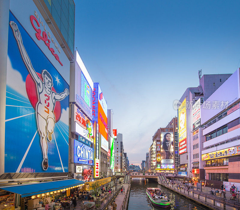 在日本大阪的道顿堀，五颜六色的广告牌照亮了大阪夜市周围的商店和零售店