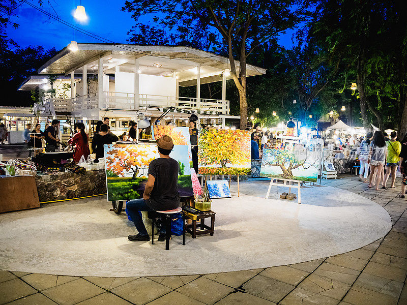 一位画家正在泰国华欣的蝉夜市画画。