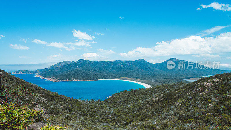 澳大利亚塔斯马尼亚的葡萄酒杯湾的白色沙滩被郁郁葱葱的绿色森林所包围