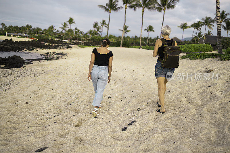 两个女人沿着沙滩向海滩走去