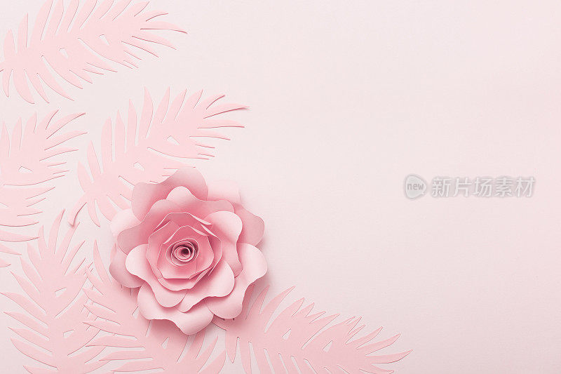 粉红色背景的鲜花贺卡。纸花平铺，俯视图