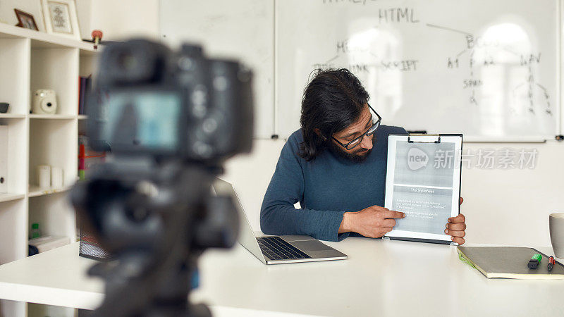 网络编码类。专业编程男导师在专业数字设备上录制关于HTML的视频博客，进行在线授课