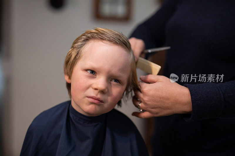 一个十几岁的金发男孩在家里理发