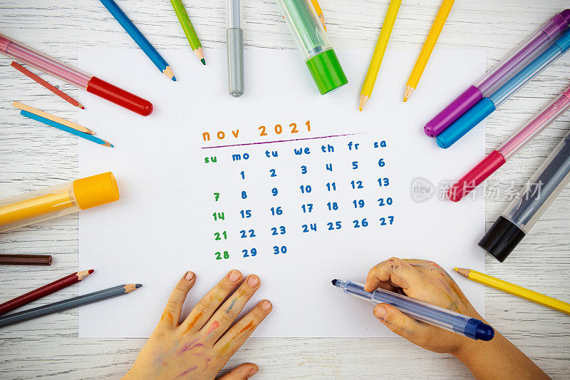 幼儿园小朋友用颜料画出2021年11月的日历。