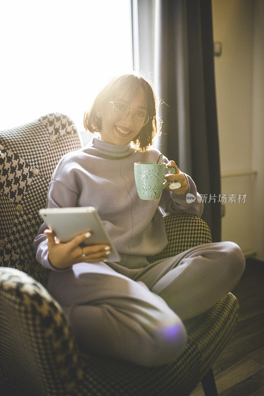 年轻女子在家看书喝咖啡放松
