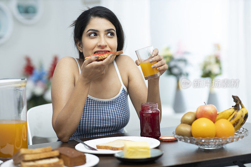 年轻妇女吃早餐的照片