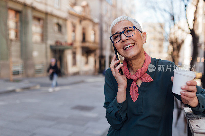 白头发的老年白人女性在用智能手机