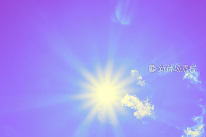 明亮的太阳和美丽的光束在天空中与轻云(色调紫色)