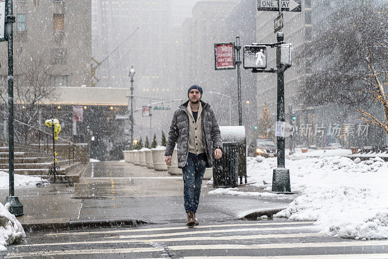 一名年轻游客，在一场大雪中穿过曼哈顿的街道