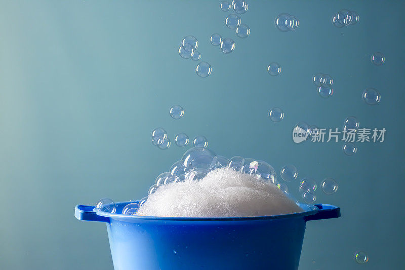 肥皂放在碗里，蓝色背景上有泡沫