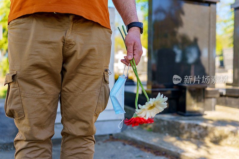 一个男人在墓地的墓碑旁献花