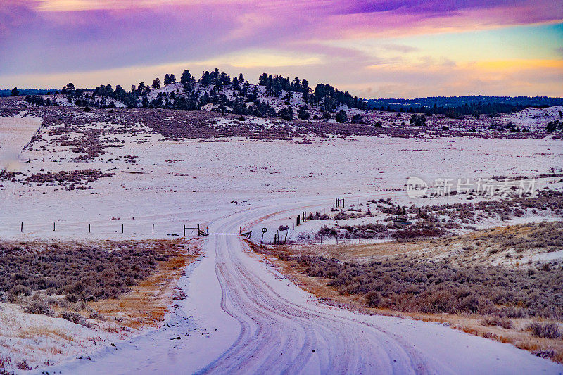 日落时分，蒙大拿山上的泥土路被白雪覆盖