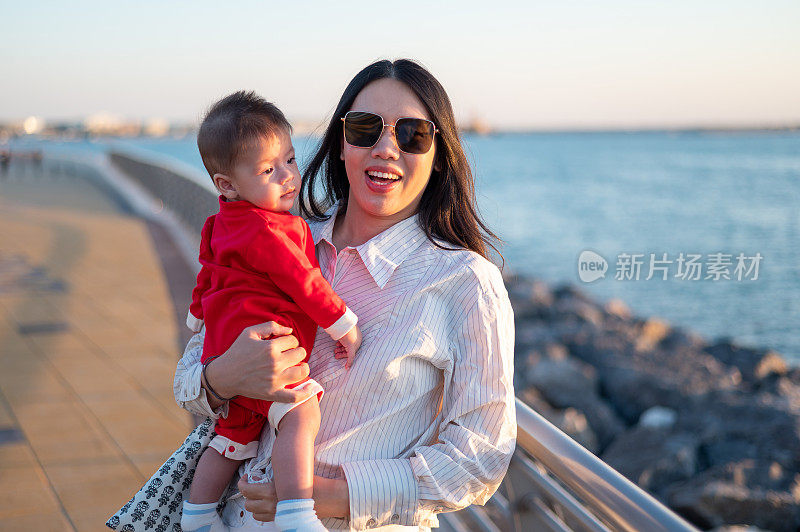 女人和她的小男孩在海边看日落