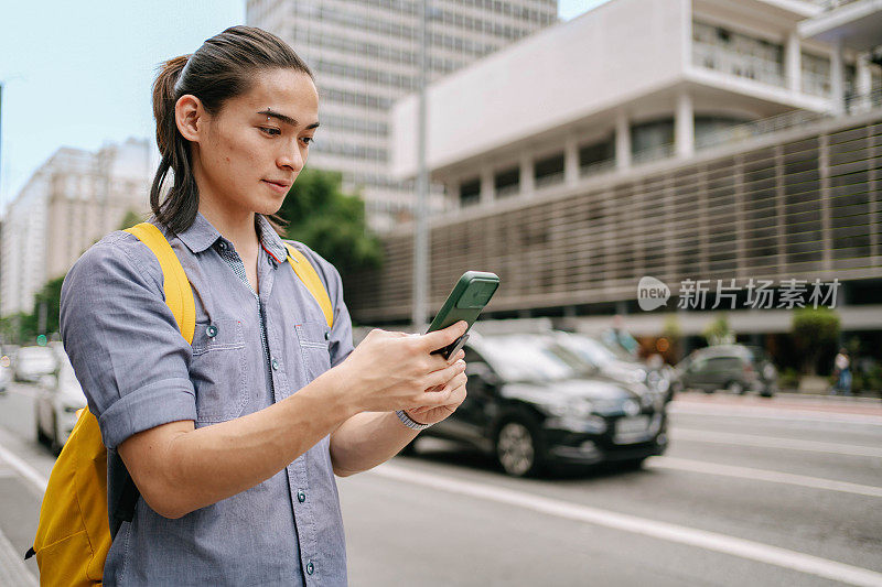 一名日本大学生在巴西圣保罗的保利斯塔大街上使用智能手机
